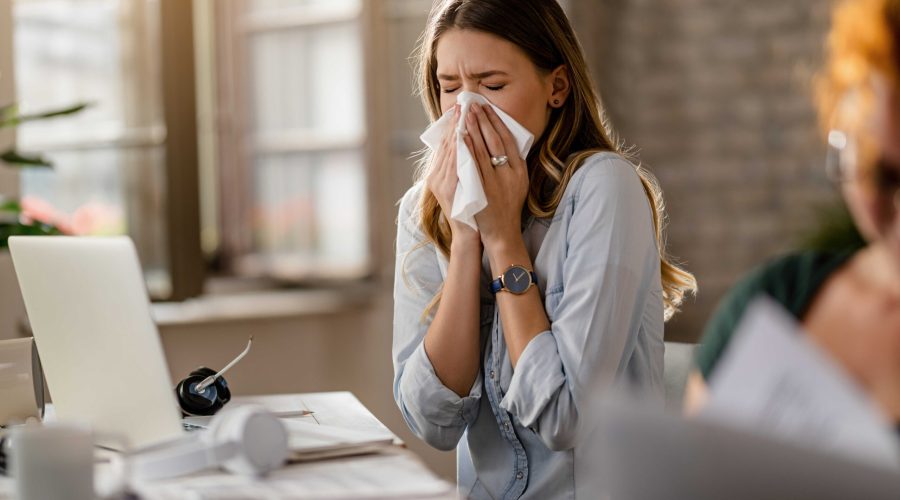 young-sick-businesswoman-sneezing-tissue-while-working-office_optimized
